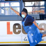 The lady posing next to the bus