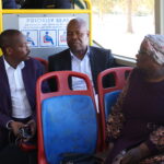 Passengers enjoying the bus ride with mayor